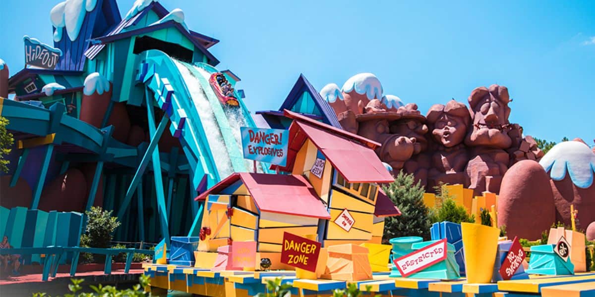 Crowds of spring break visitors walking through Universal Orlando with some attractions visible in background showing closure barriers